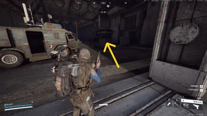 Image with a yellow arrow pointing to the guard shack containing a spare key for the Armored Transports quest.