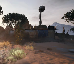 Rusty "Field Depot" Structure in a rocky and sandy environment, some trees are visible.